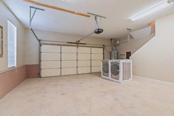 garage featuring water heater, washer and clothes dryer, and a garage door opener