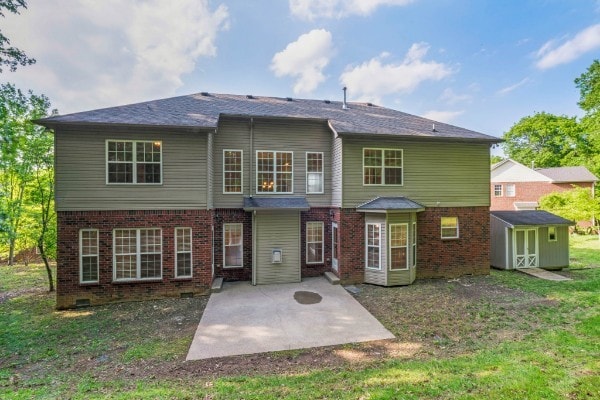 back of property with a patio and a storage unit