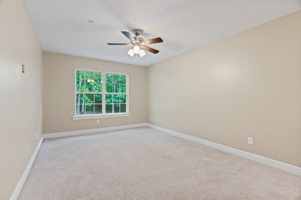 carpeted spare room with ceiling fan