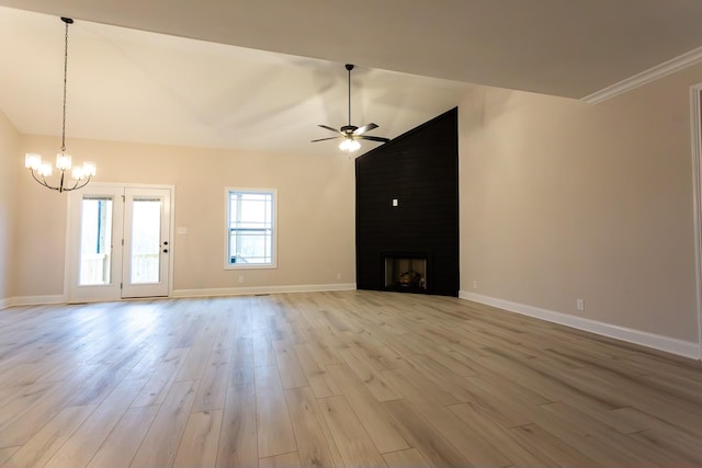 unfurnished living room featuring ceiling fan with notable chandelier, vaulted ceiling, light hardwood / wood-style floors, and a large fireplace