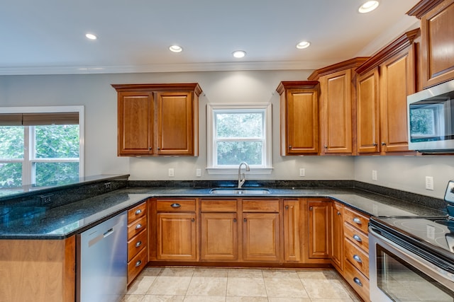 kitchen featuring sink, dark stone countertops, ornamental molding, light tile patterned flooring, and stainless steel appliances