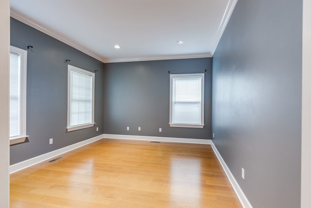 empty room with light hardwood / wood-style floors and ornamental molding