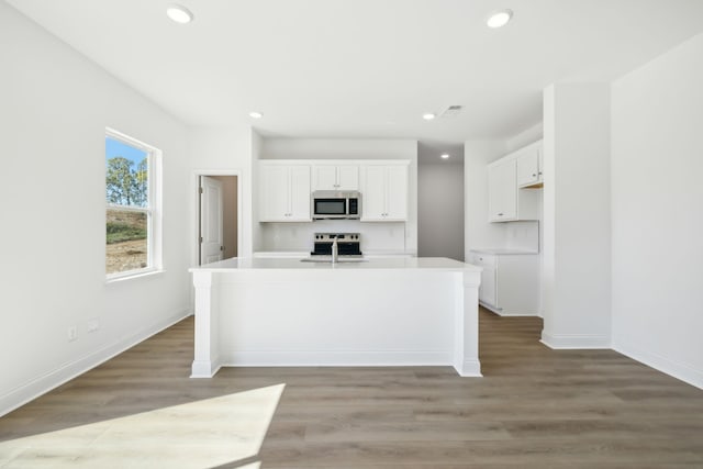 kitchen featuring white cabinetry, a kitchen island with sink, and stainless steel appliances