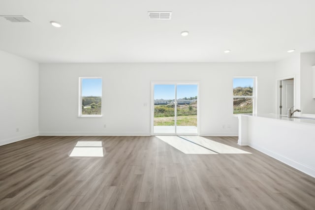 unfurnished living room featuring light hardwood / wood-style floors and a healthy amount of sunlight