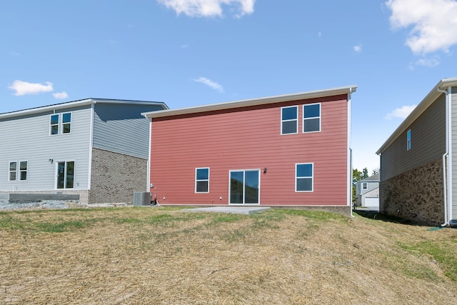 back of property featuring central AC and a lawn