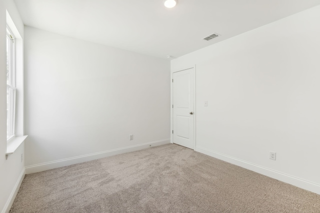 unfurnished room with a healthy amount of sunlight and light colored carpet