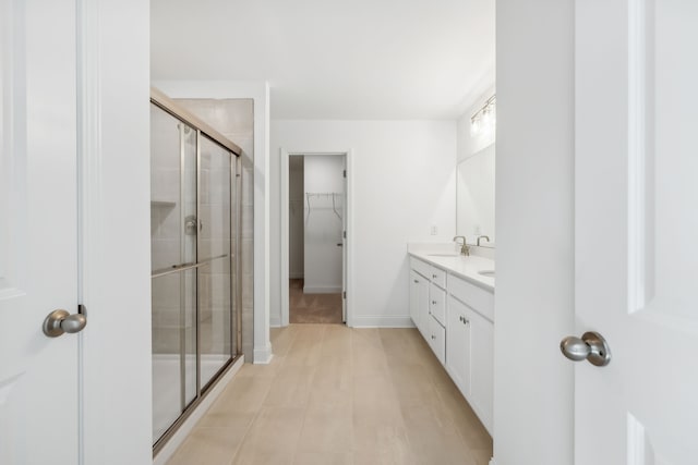 bathroom with vanity and a shower with door