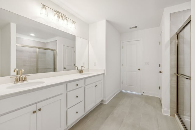 bathroom with tile patterned flooring, vanity, and a shower with door