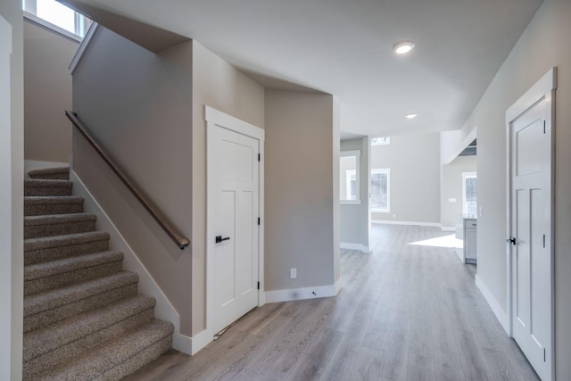 corridor featuring a healthy amount of sunlight and light hardwood / wood-style floors