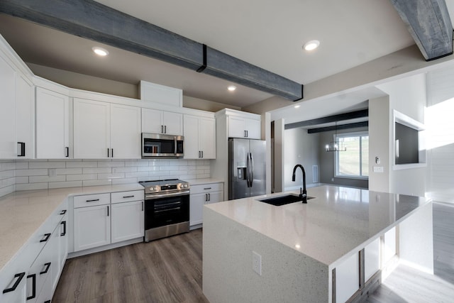 kitchen with beam ceiling, sink, white cabinetry, and stainless steel appliances