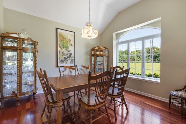 dining room with dark hardwood / wood-style flooring, a chandelier, and vaulted ceiling