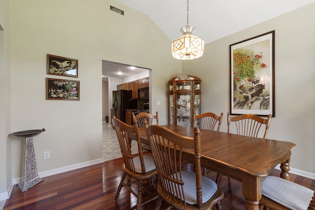 dining space featuring a chandelier, dark hardwood / wood-style floors, and lofted ceiling