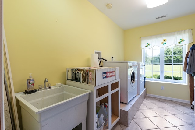 laundry room featuring washer and clothes dryer, light tile patterned floors, and sink