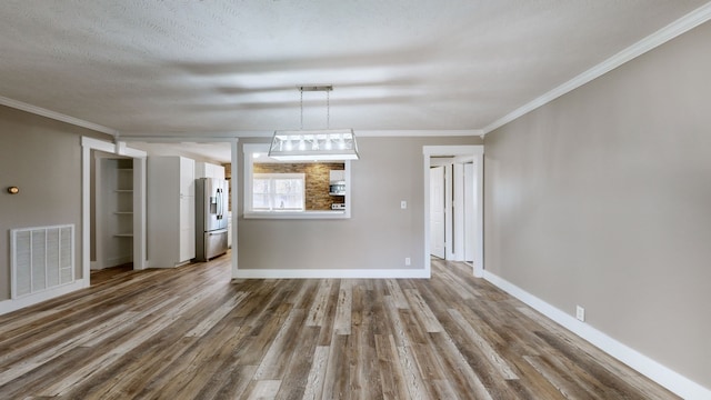 unfurnished dining area with hardwood / wood-style floors, a textured ceiling, and ornamental molding