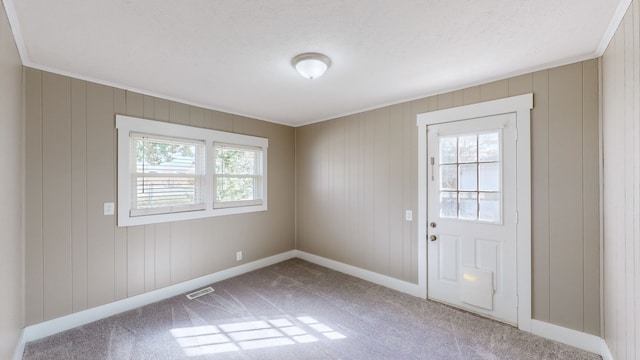 doorway with wooden walls and carpet