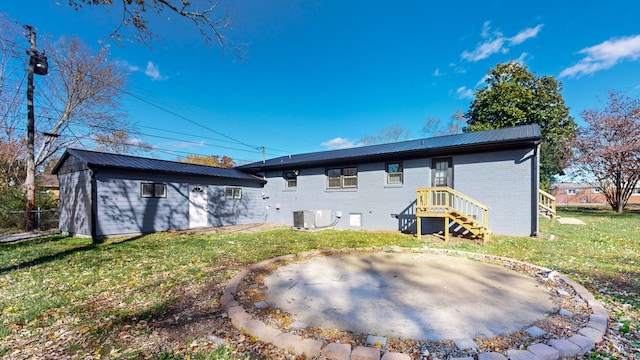 rear view of property featuring a lawn and central AC