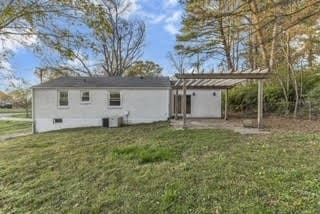 rear view of property with a pergola and a yard