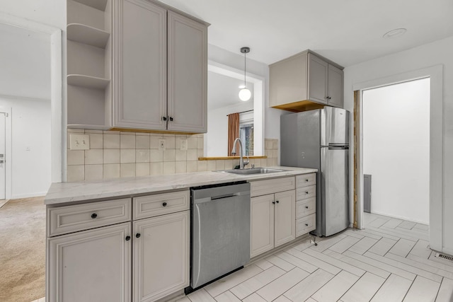 kitchen featuring sink, light stone counters, backsplash, gray cabinets, and appliances with stainless steel finishes