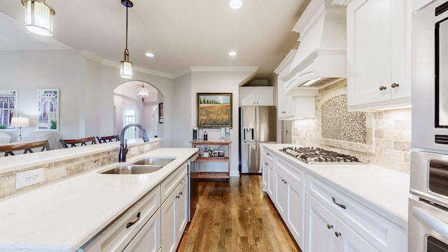 kitchen with white cabinetry, sink, premium range hood, and stainless steel appliances