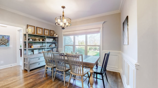 dining area featuring dark hardwood / wood-style floors, ornamental molding, and an inviting chandelier