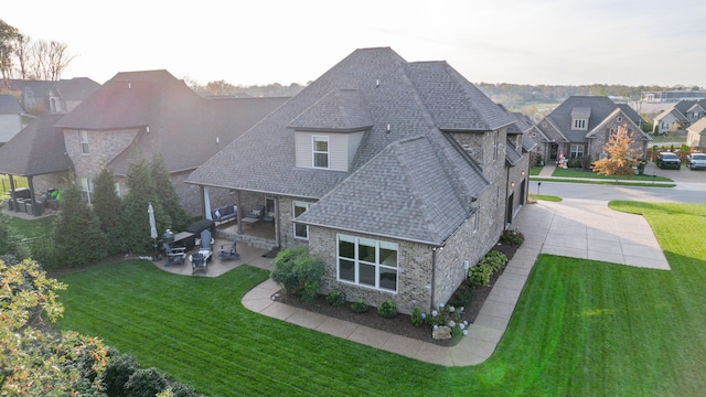 back of house with a patio area and a yard