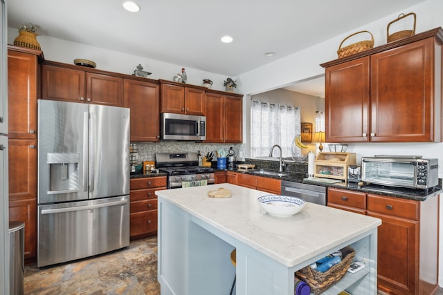 kitchen with sink, a center island, tasteful backsplash, dark stone countertops, and appliances with stainless steel finishes