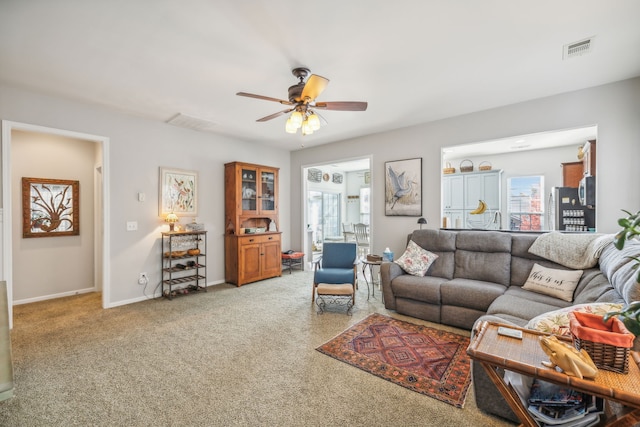 carpeted living room featuring ceiling fan