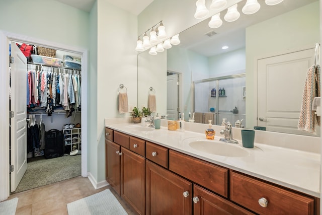 bathroom featuring tile patterned flooring, vanity, and walk in shower