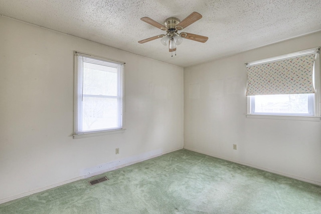 carpeted empty room with a textured ceiling and ceiling fan