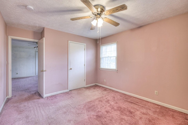 unfurnished bedroom featuring a textured ceiling, light colored carpet, and ceiling fan