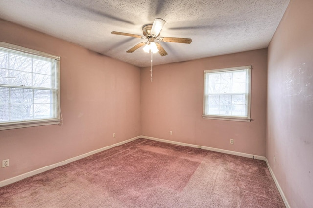 carpeted spare room featuring ceiling fan and a textured ceiling