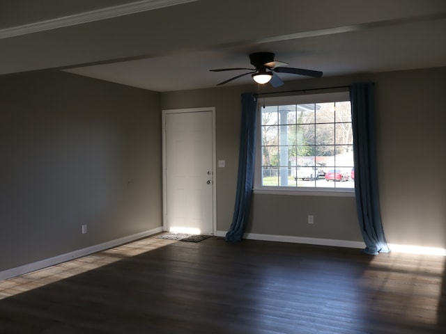 unfurnished room with ceiling fan, dark hardwood / wood-style flooring, and ornamental molding