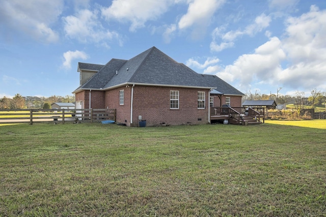 back of house featuring a wooden deck and a yard