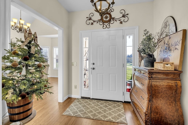 foyer entrance featuring light hardwood / wood-style floors and an inviting chandelier