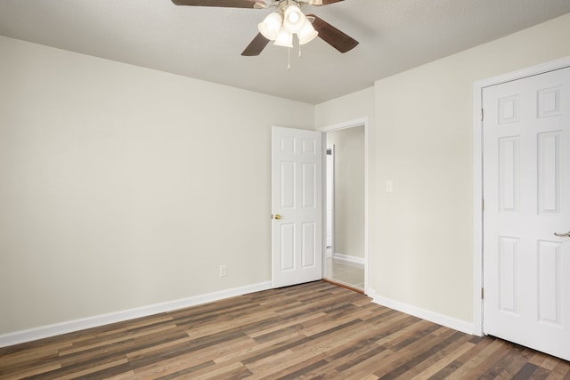 unfurnished bedroom featuring ceiling fan and dark hardwood / wood-style flooring