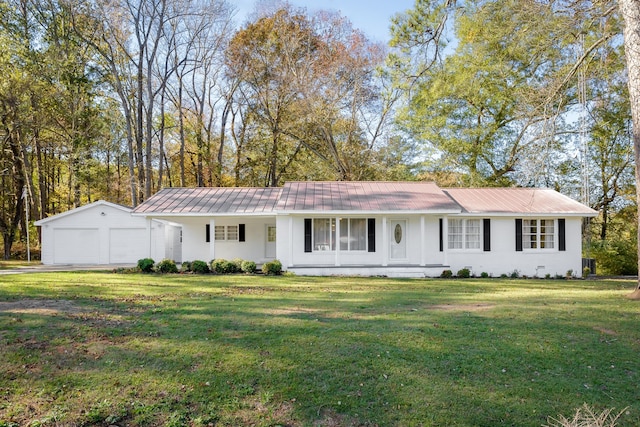 ranch-style home featuring a front lawn, covered porch, an outdoor structure, and a garage