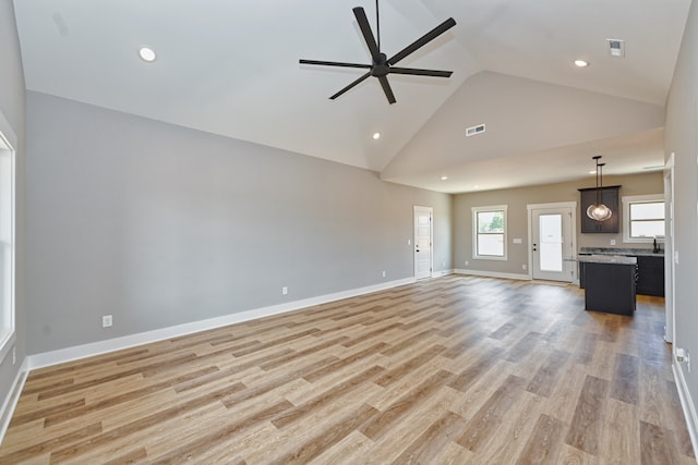 unfurnished living room featuring light hardwood / wood-style floors, high vaulted ceiling, and ceiling fan