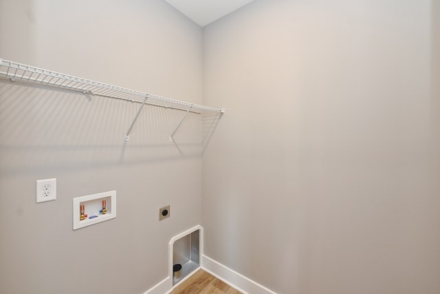 laundry room with electric dryer hookup, hookup for a washing machine, and light wood-type flooring