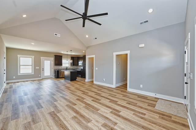 unfurnished living room featuring ceiling fan, light wood-type flooring, and high vaulted ceiling