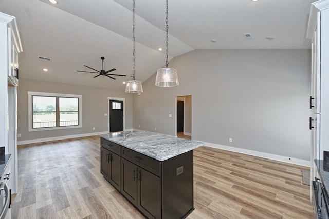 kitchen featuring dark brown cabinets, vaulted ceiling, decorative light fixtures, light hardwood / wood-style floors, and a kitchen island