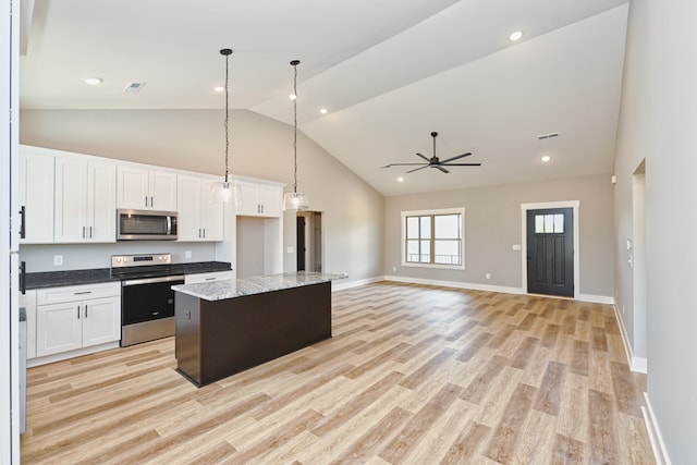 kitchen featuring a center island, white cabinets, light hardwood / wood-style flooring, ceiling fan, and appliances with stainless steel finishes