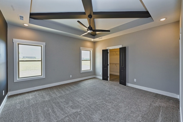 empty room with ceiling fan, dark carpet, and coffered ceiling