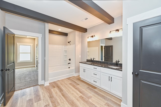 bathroom featuring beamed ceiling, hardwood / wood-style floors, vanity, and shower / bathtub combination