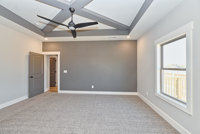 empty room with carpet flooring, ceiling fan, and beamed ceiling