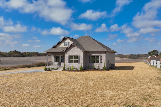 craftsman-style home with central air condition unit and a rural view