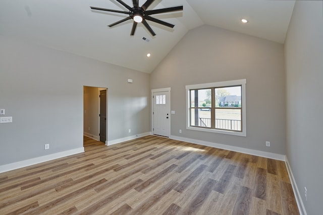 unfurnished living room featuring ceiling fan, light wood-type flooring, and high vaulted ceiling