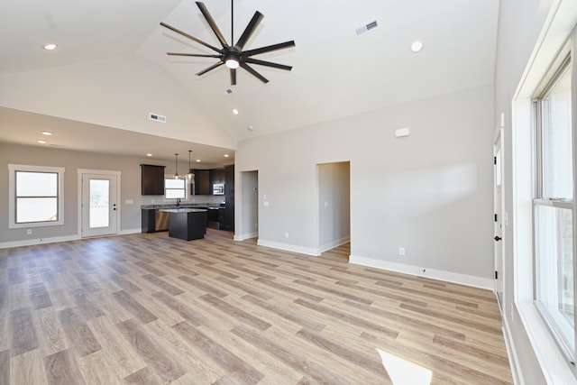 unfurnished living room featuring light wood-type flooring, high vaulted ceiling, and ceiling fan