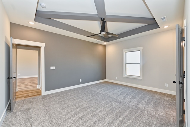 carpeted spare room featuring ceiling fan and a tray ceiling