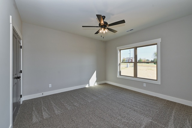 unfurnished room featuring ceiling fan and dark colored carpet