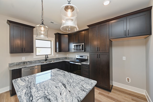 kitchen featuring light stone countertops, a center island, and stainless steel appliances